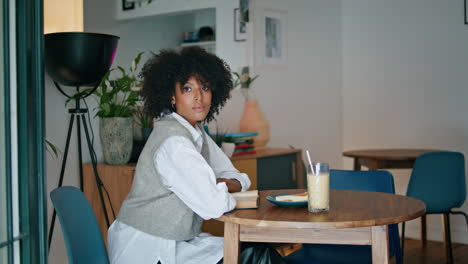 Pensive-lady-sitting-cafe-with-book-on-table.-Woman-resting-with-literature.