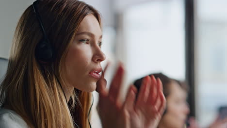 Operator-hand-taking-headset-from-computer-closeup.-Smiling-woman-talk-contact