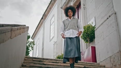 Girl-walking-down-stairs-city-cloudy-day.-Woman-enjoy-calm-stroll-on-staircase.