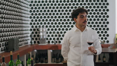 Man-tasting-red-wine-winery-restaurant-vertical-closeup.-Sommelier-trying-taste