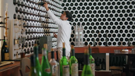 Professional-sommelier-choosing-wine-cellar-vertical.-Specialist-taking-bottle