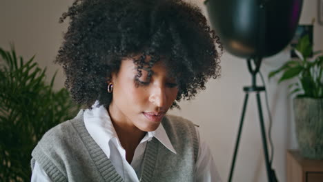 Portrait-relaxed-african-brunette-sitting-at-cozy-interior.-Curly-woman-posing.