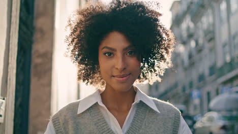 Brown-skin-woman-walking-sunny-city-street-closeup.-Girl-smiling-at-urban-stroll