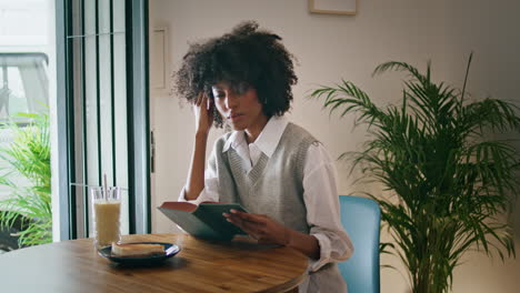 Chica-Pasando-La-Página-Del-Libro-Sentada-En-La-Mesa-Del-Café-Sola.-Mujer-Leyendo-Literatura.