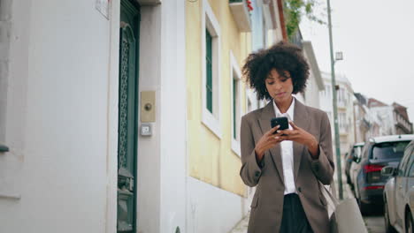 Frau-Geht-Mit-Smartphone-Durch-Die-Stadtstraße.-Afroamerikanisches-Mädchen-Schaut-Am-Telefon-Vorbei.