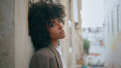 Lady-standing-city-street-leaning-on-wall-close-up.-Portrait-attractive-woman.