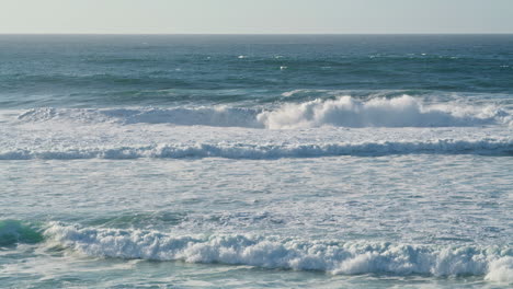 White-sea-waves-rolling-coastline-on-sunny-morning.-Storming-ocean-water-foaming