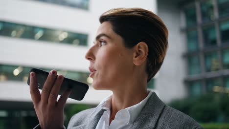 Corporate-executive-recording-voice-message-closeup.-Successful-woman-use-mobile