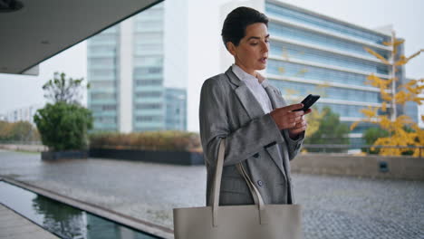 Mujer-Del-Centro-Navegando-Por-Teléfono-Inteligente-Caminando-Sola.-Gerente-Pensativo-Respondiendo