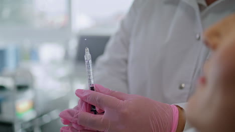 Professional-cosmetologist-preparing-syringe-with-medicines-in-clinic-close-up.