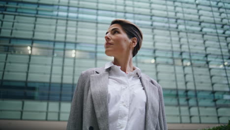 Successful-businesswoman-admiring-office-buildings.-Pensive-woman-executive-rest