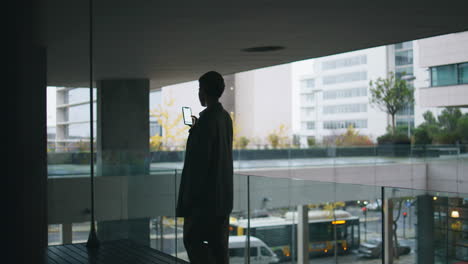 Woman-silhouette-using-mobile-phone-at-urban-view.-Relaxed-businesswoman-scroll