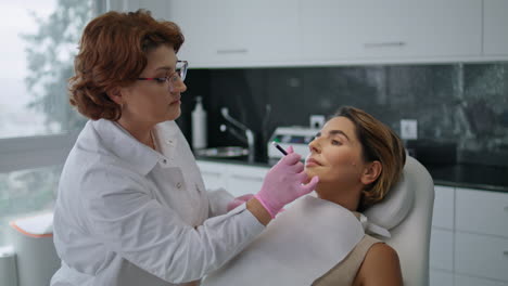 Esteticista-Dibujando-Líneas-De-Corrección-En-La-Cara-De-La-Mujer-Antes-Del-Procedimiento-De-Levantamiento.