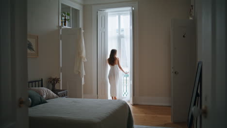 Domestic-girl-open-curtains-at-morning-indoors.-Anonymous-woman-looking-window