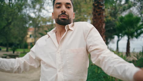 Portrait-energetic-latino-dancer-shaking-shoulders-performing-dance-in-garden.