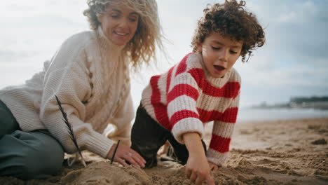 Madre-Niño-Construyendo-Figuras-De-Arena-En-La-Playa-Del-Océano.-Feliz-Fin-De-Semana-Relajante-En-Familia