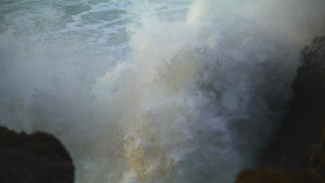 Enormes-Olas-Golpean-La-Playa-De-Rocas-En-Cámara-Lenta.-Peligrosa-Ruptura-En-El-Agua-Del-Océano