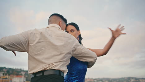 Couple-tango-dancers-performing-hot-choreography-in-front-cloudy-sky-close-up