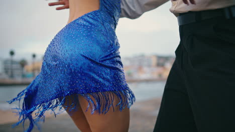 Closeup-woman-dancer-hips-moving-energetic-in-blue-dress-outside.-Couple-dancing