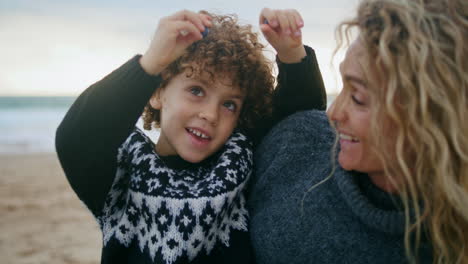 Closeup-family-having-fun-resting-ocean-shore-together.-Happy-kid-feeding-mother