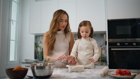 Positive-family-decorating-pie-at-kitchen-closeup.-Funny-child-girl-eating-apple