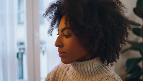 Curly-girl-working-home-evening-close-up.-Serious-lady-looking-distance-thinking