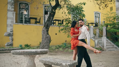 Hot-latino-dancers-posing-in-city-park-summer-day.-Woman-leaning-on-partner.