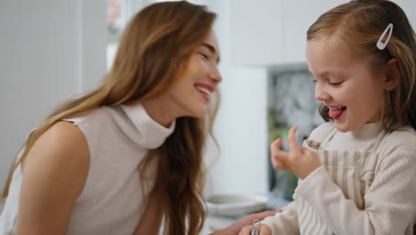 Süßes-Kind-Berührt-Das-Gesicht-Der-Mutter-In-Der-Küche,-Porträt,-Lachende-Mutter-Knüpft-Bindung-Zu-Tochter