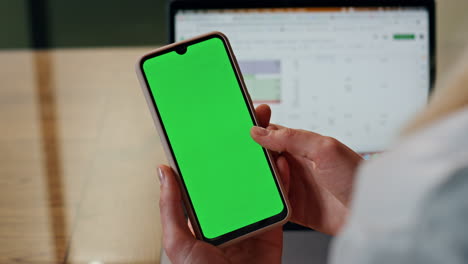 Lady-finger-swiping-mockup-smartphone-at-table-closeup.-Woman-hand-holding-phone