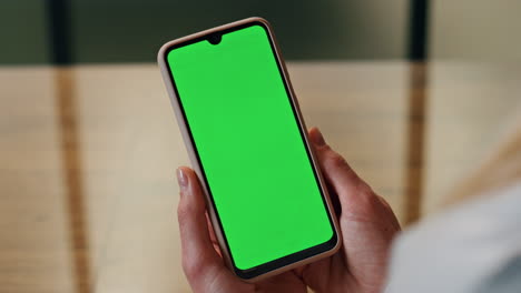 Greenscreen-phone-woman-hands-holding-at-office-close-up.-Person-watching-screen