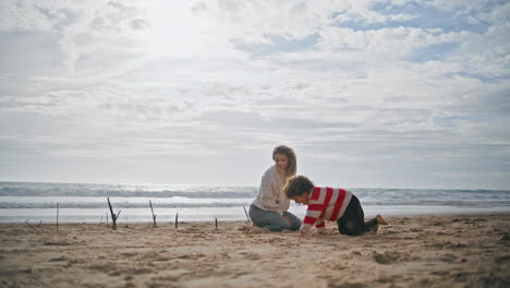 Vorschuljunge-Spielt-Mit-Junger-Mutter-Am-Strand.-Glückliches-Elternkind-Ruht-Sich-Zusammen-Aus