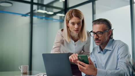 Two-employees-working-together-office-closeup.-Business-people-discussing-work