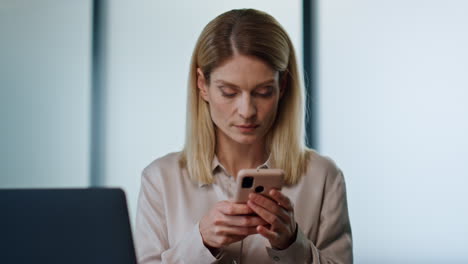 Fokussierte-Frau,-Die-SMS-Schreibt,-Telefon-Büroporträt.-Ernster-Manager-Am-Laptop-Arbeitsplatz