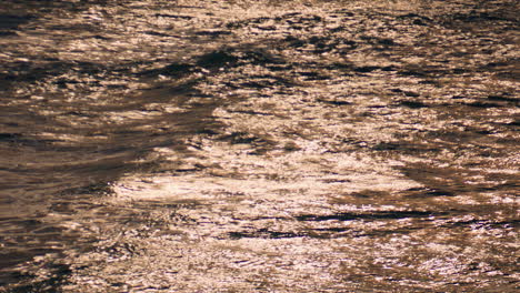 Schimmerndes-Wasser-Reflektiert-Das-Sonnenlicht-An-Einem-Sommertag.-Ruhige,-Glänzende-Oberflächenstruktur