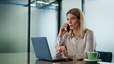 Confident-manager-speaking-cellphone-office-interior.-Closeup-ceo-calling-mobile