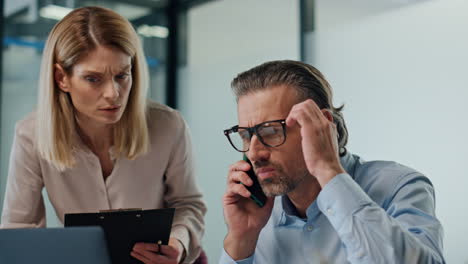 Confused-colleagues-working-computer-at-meeting-room.-Partners-having-problems