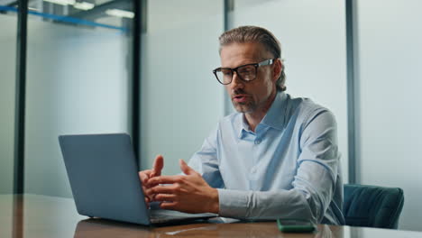 Serious-boss-video-chatting-laptop-closeup.-Confident-man-having-web-video-call