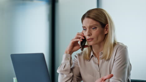 Upset-boss-talking-cellphone-at-office-close-up.-Sad-woman-loser-fix-problem