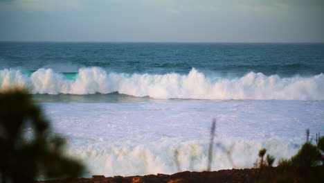 Powerful-white-waves-rolling-towards-tropical-coastline.-Foamy-ocean-swelling