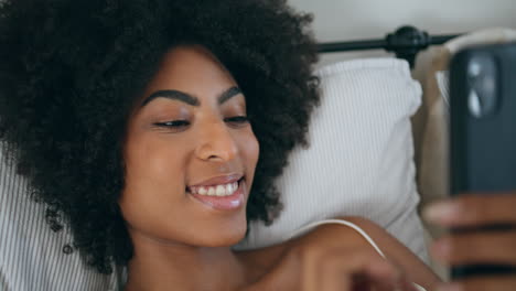 Mujer-Sonriente-Mirando-La-Cámara-En-El-Retrato-De-La-Cama.-Niña-Africana-Escribiendo-Teléfono-Móvil