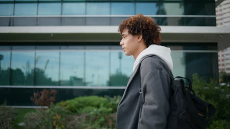 Busy-guy-checking-time-at-street-closeup.-Curly-student-hurry-to-college-outdoor