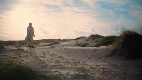 Gelassene-Frau-Spaziert-Durch-Sanddünen.-Ruhige-Modellsilhouette,-Die-Den-Morgen-Am-Meer-Genießt