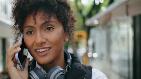 African-woman-talking-phone-walking-on-city-street-close-up.-Girl-finish-call