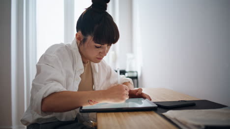 Artista-Del-Tatuaje-Dibujando-Un-Boceto-En-Un-Lugar-Acogedor-En-Primer-Plano.-Mujer-Usando-Tableta-Gráfica