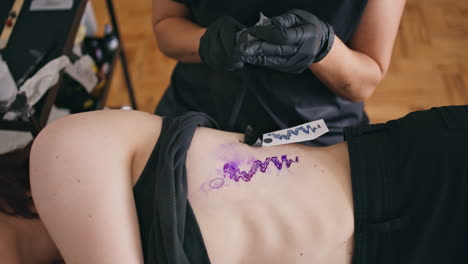 Tattooist-hands-assembling-machine-at-salon-closeup.-Woman-preparing-to-session