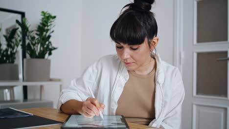 Inspired-artist-using-tablet-computer-at-studio-closeup.-Focused-woman-drawing