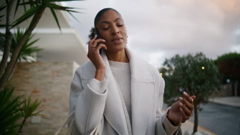 Attractive-african-american-talking-phone-on-street.-Wealthy-rich-woman-walking