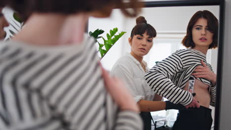 Serious-client-looking-mirror-reflection-tattoo-studio.-Master-leaving-picture