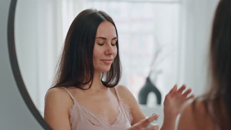 Smiling-woman-applying-antiperspirant-at-home.-Lady-spraying-armpits-deodorant