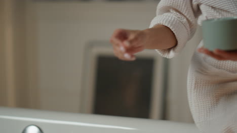 Woman-hand-bath-salt-putting-at-water-indoors-closeup.-Lady-enjoying-evening